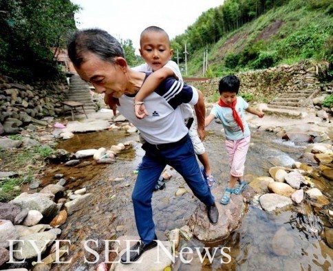 身兼校長及老師的祝雲漢每週要跨過小河到山口接孩子們上課。（圖：網絡照） 