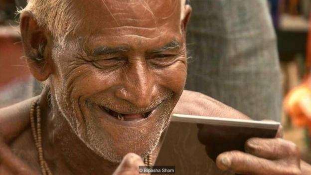 老乞丐看見自己的照片後笑了。圖／BBC