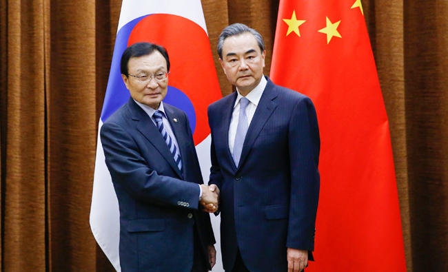 中國外交部長王毅 (右) 18日與南韓特使李海瓚會晤北京。圖／法新社