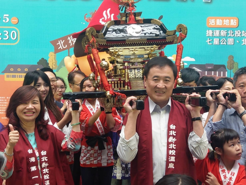 陳副市長(右)、觀光傳播局陳思宇局長(左二)及臺北市溫泉發展協會周水美理事長(左一)一起抬神轎預祝溫泉季順利圓滿成功